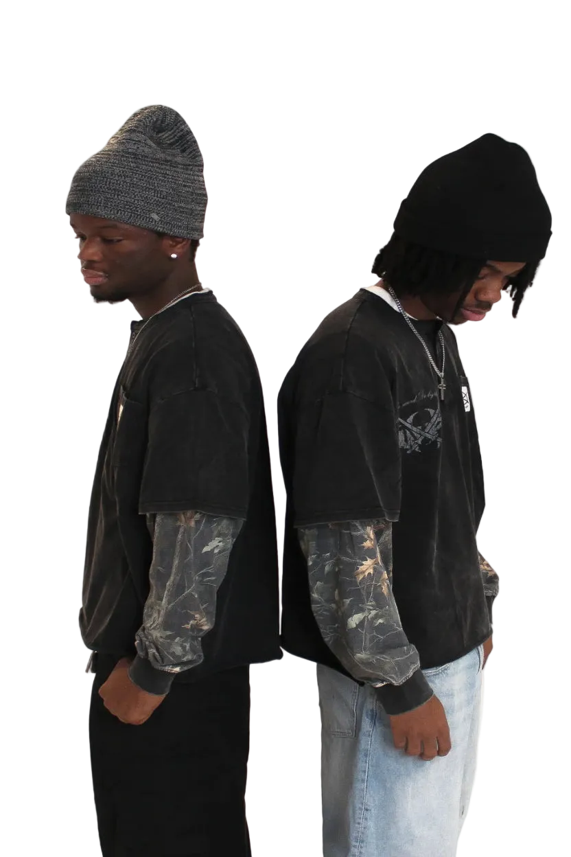 Two people wearing black hoodies and beanies on a plain background